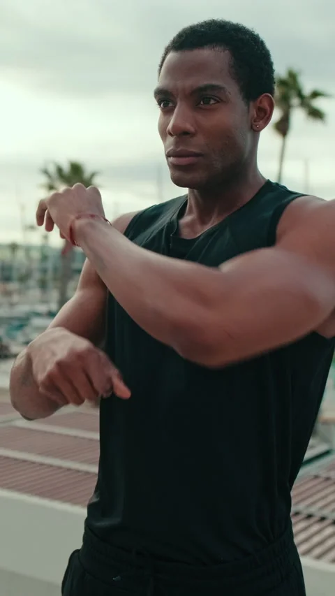 Vertical video, Young Man Stretching Before a Workout by the Marina Stock Footage 315398814