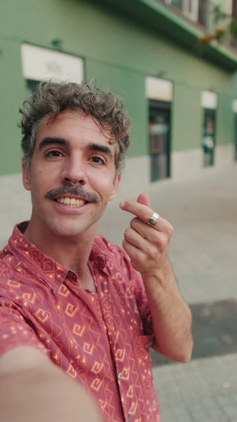 Vertical video, Young Man Taking a Selfie Video on Sidewalk Stock Footage 320378476
