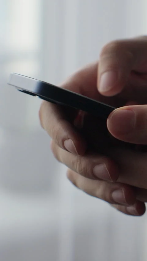 Vertical video. Young man using smartphone for web chat, news reading Stock Footage 343763883