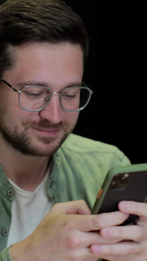 Vertical video. Young man using smartphone at cafe. Stock Footage 345237035