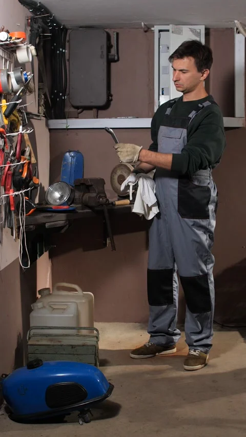 Vertical video young man wearing work overalls and safety gloves cleaning a Stock Footage 342761194