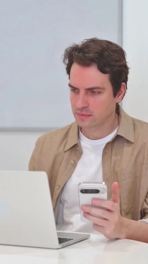 Vertical Video, Young Man Working on Phone and Laptop Video stock 318048206