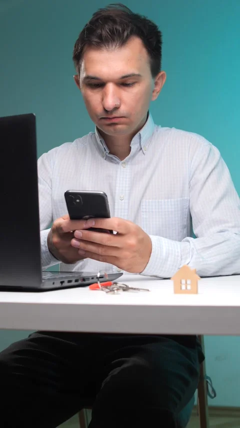 Vertical video young man working remotely on his laptop and smartphone Stock Footage 342761174