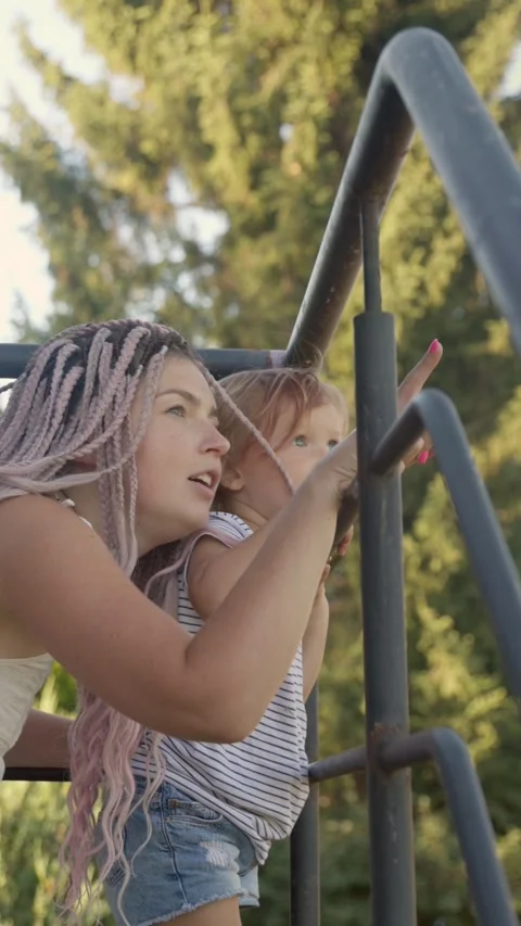 Vertical video. A young mother talks to her little daughter on the balcony of a Video stock 283628895