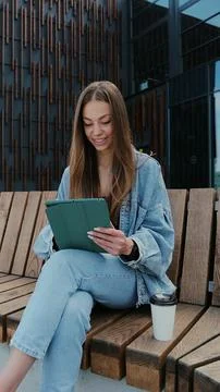Vertical video. Young person using digital tablet on a sunny day. Freelance a 스톡 사진