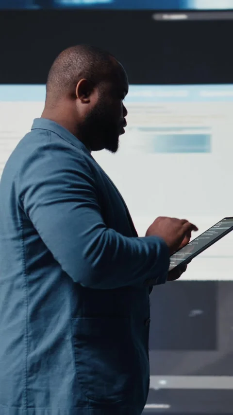 Vertical Video Young professional engineer focused on coding with tablet at an Stock-Footage 312177490