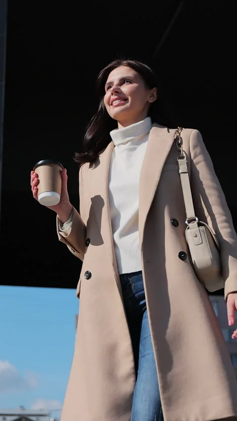 Vertical video. Young professional multitasking on the street with coffee 動画素材 344108377