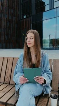 Vertical video. Young woman using tablet computer outdoors. Girl reading news Stock Photos