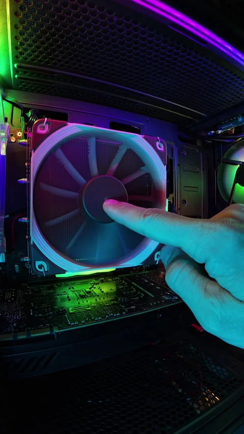 Vertical video. A zoomed-in view inside a gaming PC, featuring a hand stopping Video stock 289765033