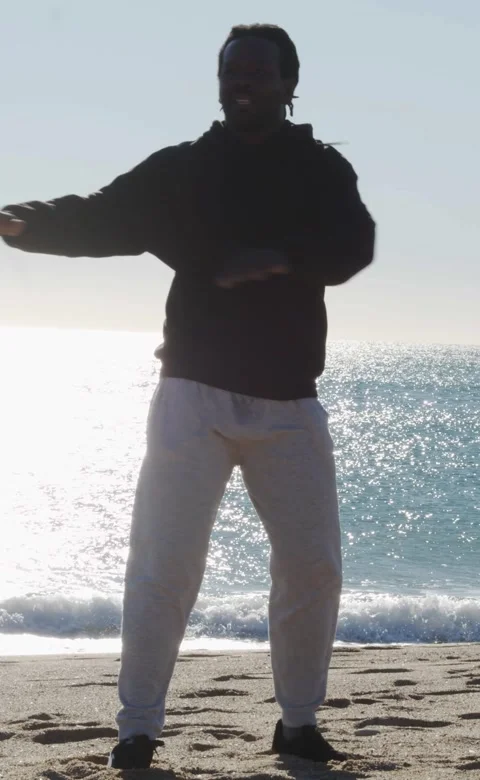 Vertical video.Afro man doing stretching on the beach Stock Footage 247490769