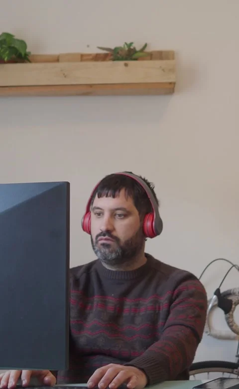 Vertical video.Bearded man working in front of a computer in a modern office Stock Footage 208925820