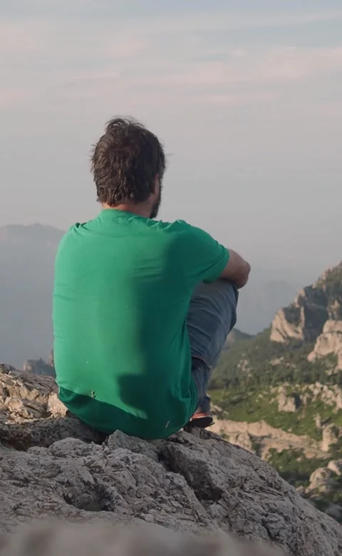 Vertical video.Introspective adventurous man sitting on top of the mountain Stock Footage 209160466