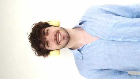 Vertical video.Italian man looking at camera laughing with headphones Stock Footage 207181478