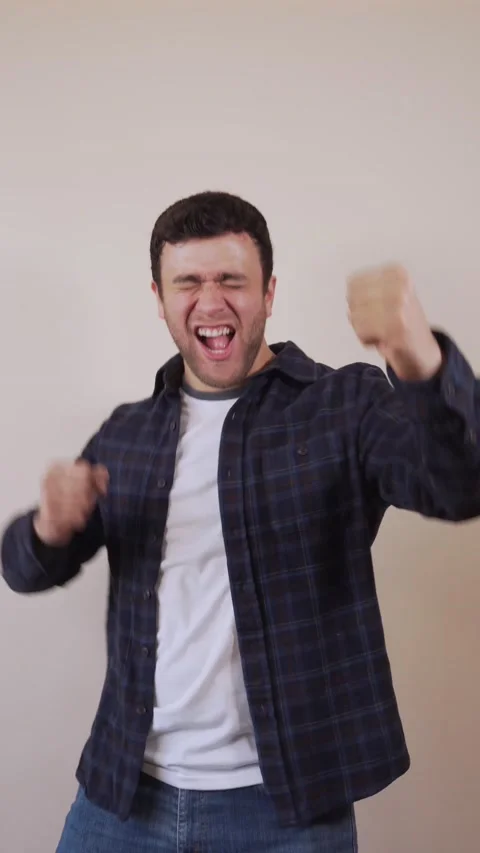 Vertical video.white man, cheerfully celebrating a great achievement, with .. Stock Footage 236678261