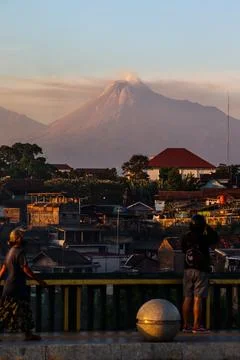 Vertical View of Active Mount Merapi Volcano at Sunset with Person Silhouet.. 库存照片