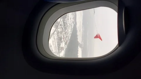 Vertical. the view from the airplane window, flying over the snow covered city Video stock 125993611