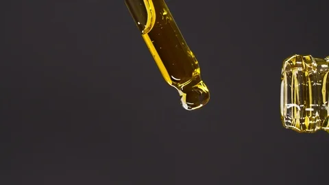 Vertical view of aromatheraphy oil drops dripping from dropper into a bottle 스톡 동영상 126148830