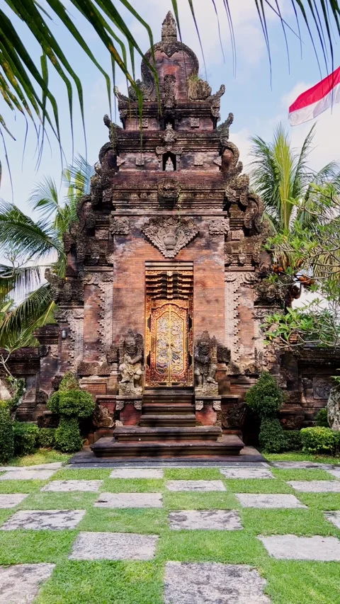 Vertical View of Balinese Hindu Temple Entrance with Stone Carvings and Palm Stock Footage 331777889