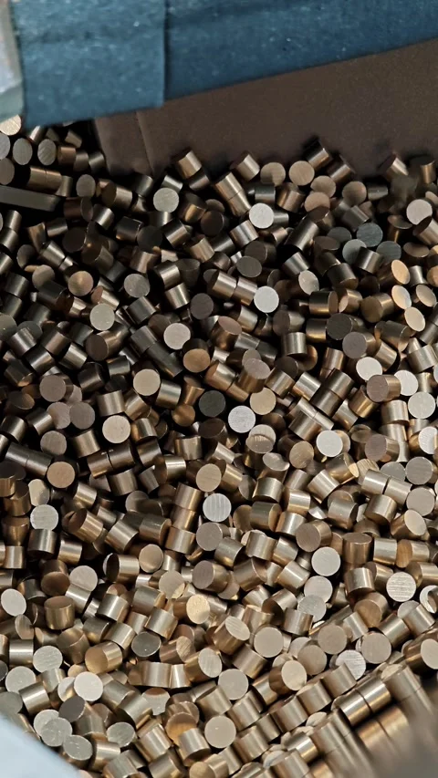 Vertical view of a blue plastic box half filled with brass cylindrical parts. Stock-Footage 329326877