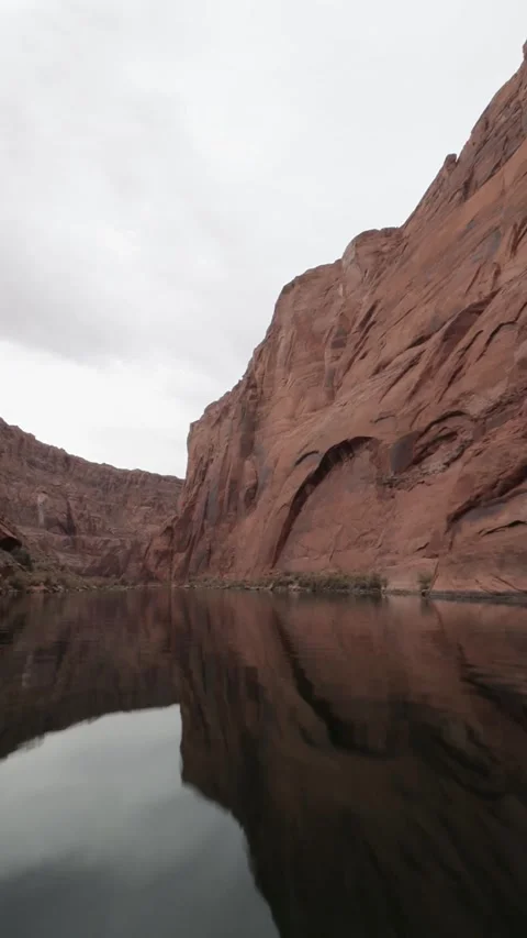 Vertical View Of Boat Going Up The Colorado River Below Glen Canyon Dam Stock Footage 306330079