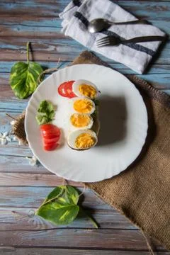 Vertical view of boiled egg slices on bacon Stock Photos
