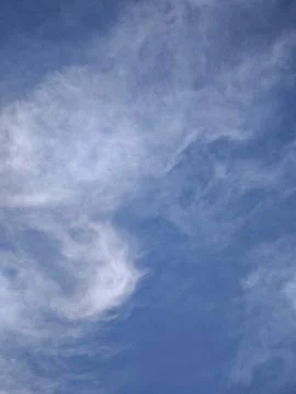 Vertical view of bright blue sky with wispy clouds and copy space Stock Photos