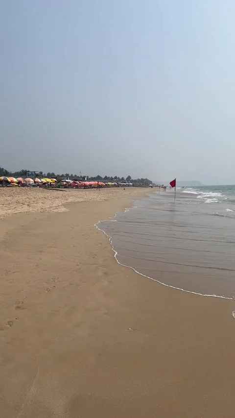 Vertical view of Calangute Beach shoreline with waves and red flag Goa India Vídeos de archivo 343150104