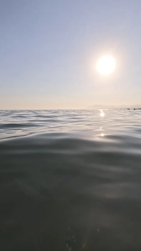 Vertical view of calm sea surface with sun Stock Footage 332065261
