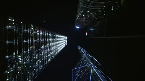 Vertical View Capturing Illuminating Skyscrapers Rising Against Dark Nighttime Stock Footage 310602760