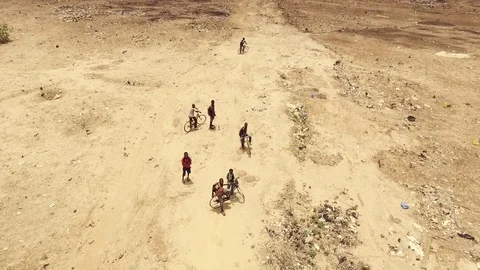 Vertical view children on their bikes in a desertic area Stock Footage 80529450