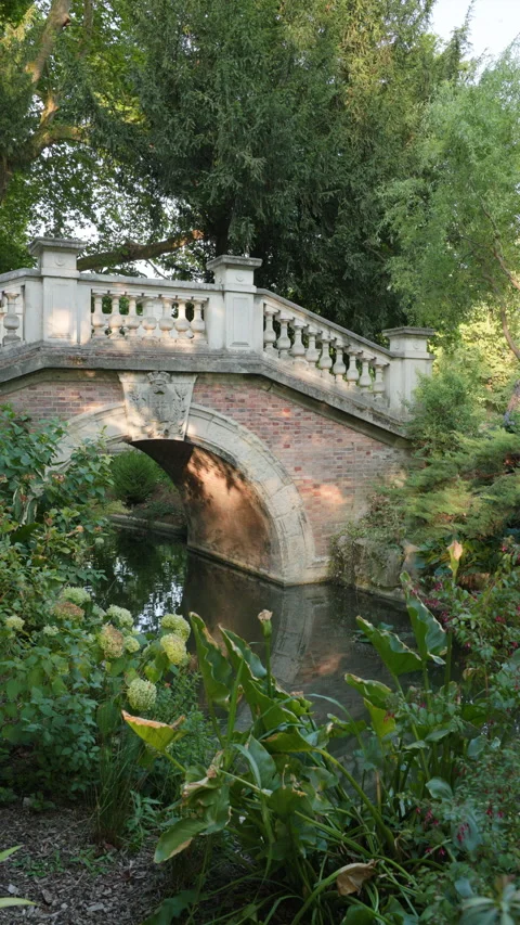 Vertical View of Classical Stone and Brick Arch Bridge Surrounded by Lush Greene Stock Footage 340477403