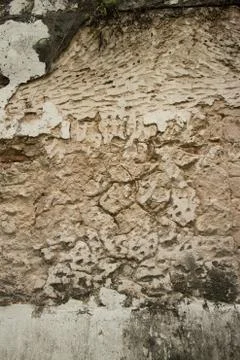 Vertical view of Colonial stucco wall in Asia with deep fissures, erosion, an Stock Photos