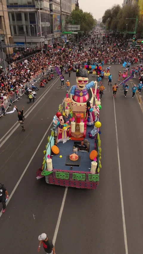 Vertical view of colorful Día de los Muertos parade as people stand and watch Stock Footage 308518933