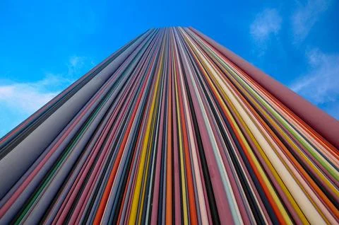 Vertical view of colorful, striped skyscraper against a clear blue sky, emp.. Stock Photos