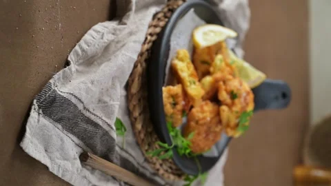 Vertical view of crispy cod fish fritters in a black skillet 動画素材 338365548
