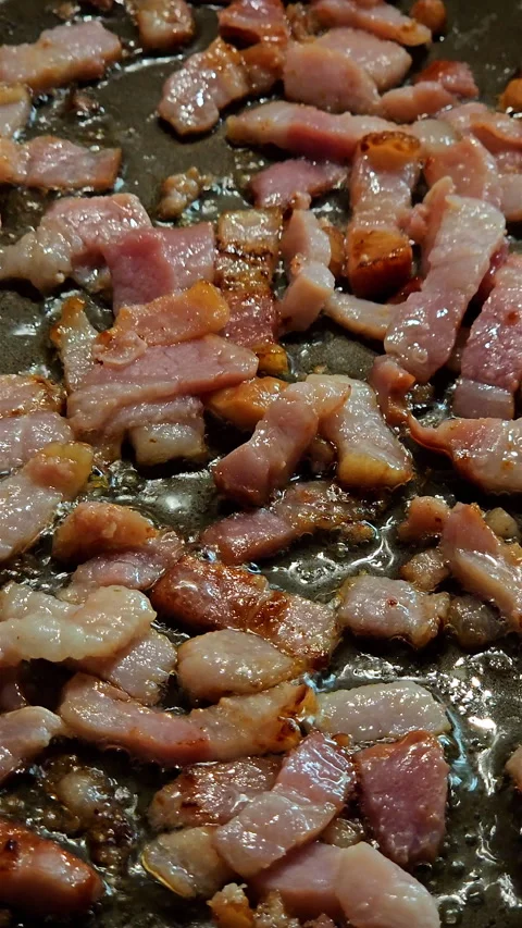 Vertical view of cured pork guanciale strips sizzling in hot frying pan. Vídeos de archivo 347884397