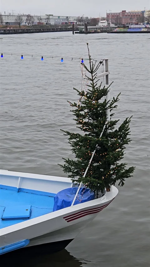 Vertical view of decorated Christmas tree mounted on bow of boat in harbour. 스톡 동영상 347884410