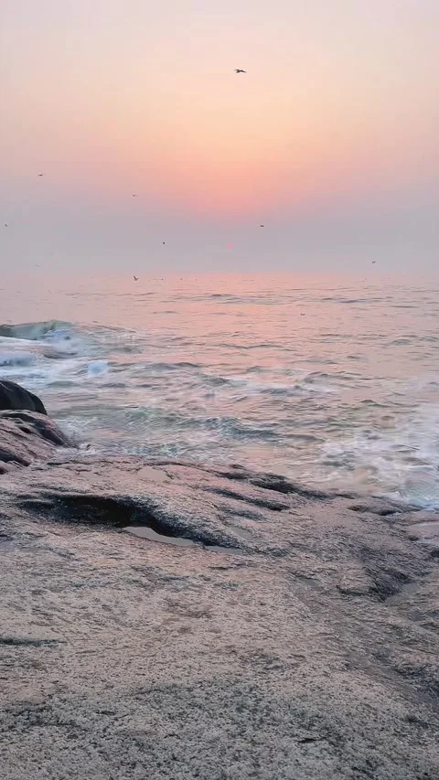 Vertical View of Deep Pink Sunset over Ocean Waves Crashing on Rocks Stock Footage 330144217