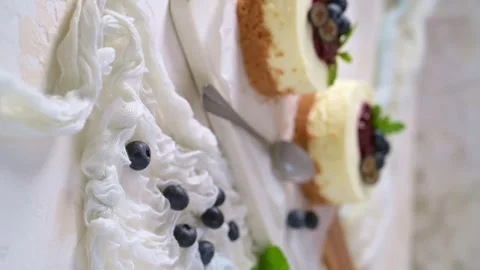 Vertical view of delicious mini cheesecakes served with blueberry compote and fr Stock Footage 343797293