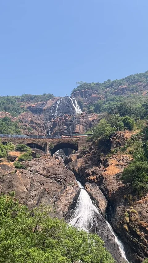 Vertical view of Dudhsagar Waterfalls with train crossing bridge Goa India Vídeo Stock 343150111