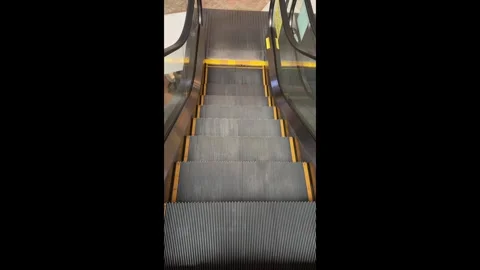 Vertical view of an escalator between floors inside a modern shopping mall. Video stock 338040633