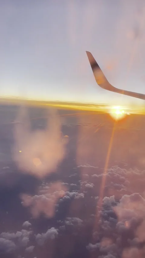 Vertical view evening cloudy sky from blurred frozen plane porthole with sunset Stock Footage 293962806