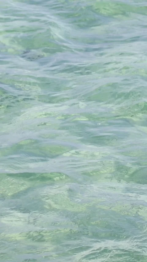 Vertical View of Gentle Ripples on Clear Light Green Water Stock Footage 327831959