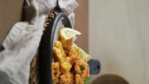 Vertical view of golden cod fish fritters in a black skillet 動画素材 338365542