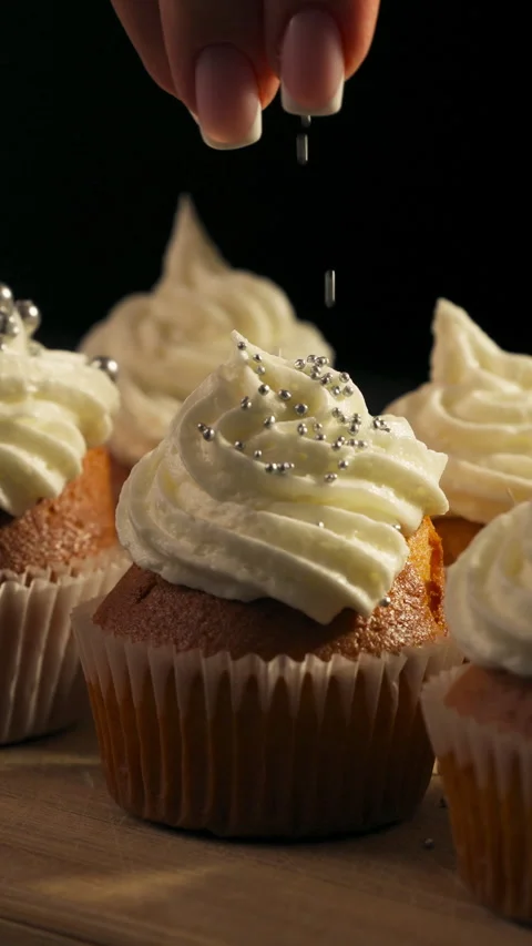 Vertical View Of A Gourmet Cupcake With White Frosting And Shiny Candy Pearls Video stock 329004503