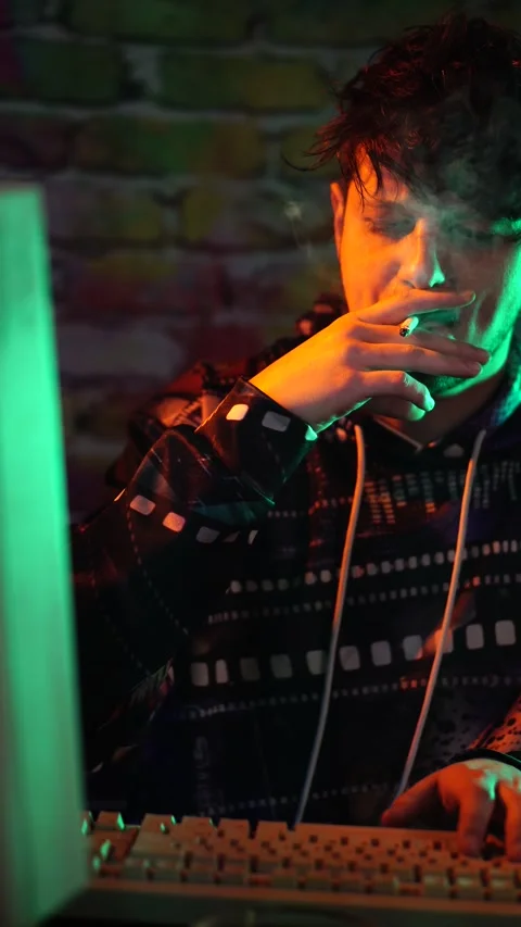 Vertical View of Hacker or Programmer Smoking Cigarette in Front of Monitor of Stock Footage 301706031