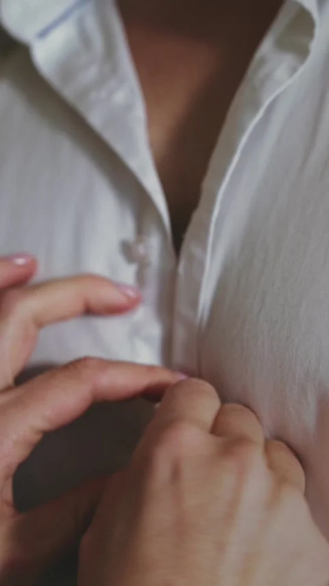 Vertical view of human hands unbuttoning shirt Stock Footage 225868981