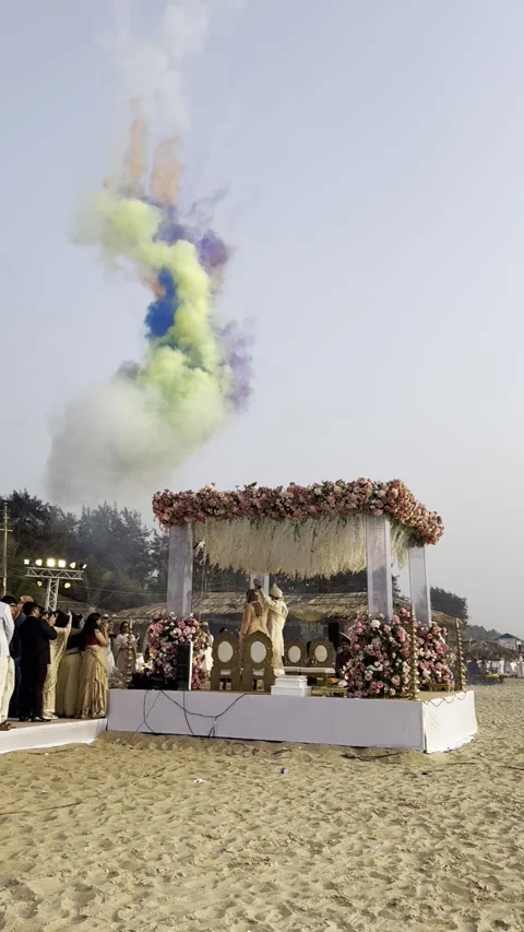 Vertical view of Indian beach wedding with Holi color smoke bombs in Goa Видео 342996799