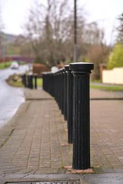 Vertical view of inline black metal road blockers to prevent vehicle parking Stock Photos