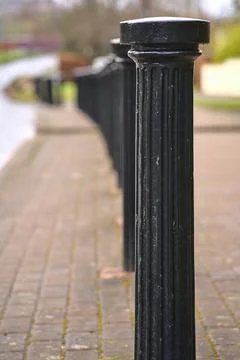 Vertical view of inline black metal road blockers to prevent vehicle parking Stock Photos